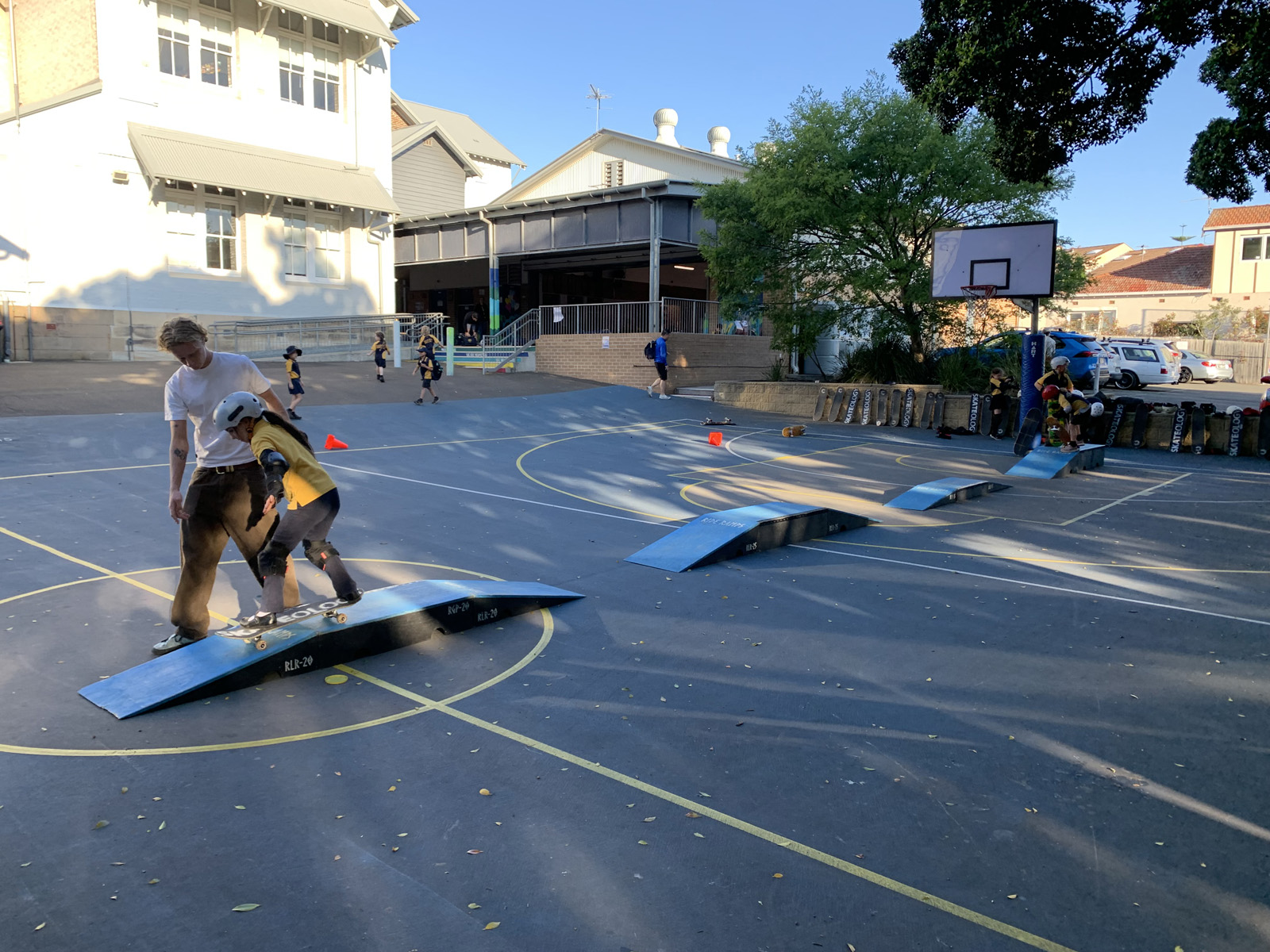 Kids skateboarding at OOSH in school yard.